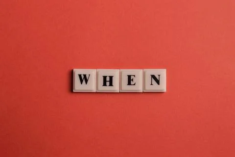 Square letters with text WHEN isolated on red background Stock Photos