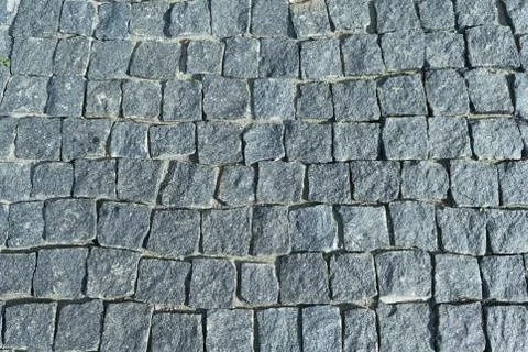 Square lined with cobblestone or stone pavement, walkway or road. Stock Photos