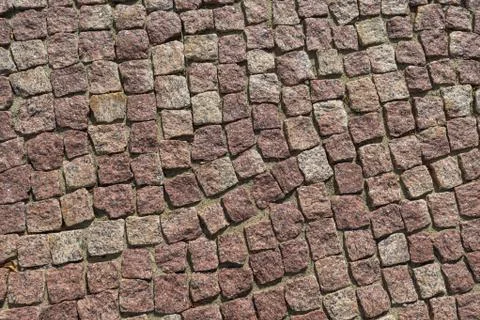 Square lined with cobblestone or stone pavement, walkway or road. Stock Photos