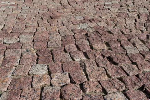 Square lined with cobblestone or stone pavement, walkway or road. Stock Photos