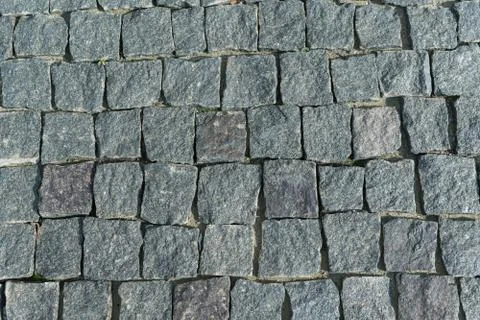 Square lined with cobblestone or stone pavement, walkway or road. Stock Photos