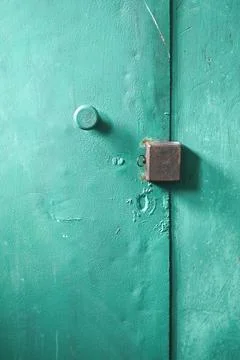 Square lock sits on painted iron background in corridor. Stock Photos