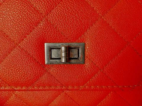 Square or box pattern on orange bag with flap showing lock button. Stock Photos