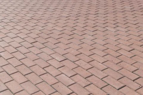 The square or on a sidewalk lined with brown tiles, paving stones. Stock Photos