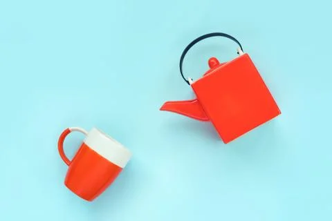 Square orange teapot and a mug. Creative concept. Stock Photos