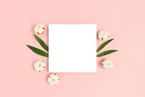 Square paper card mockup with frame made of cotton and green leaves Stock Photos