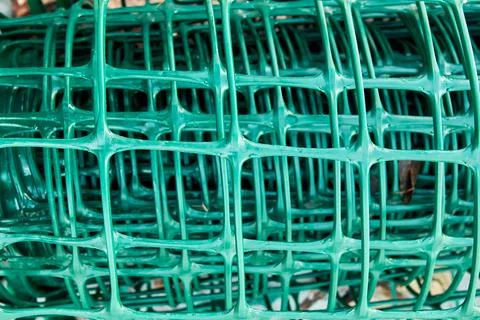 Square pattern green plastic flexible garden fence rolled up Stock Photos