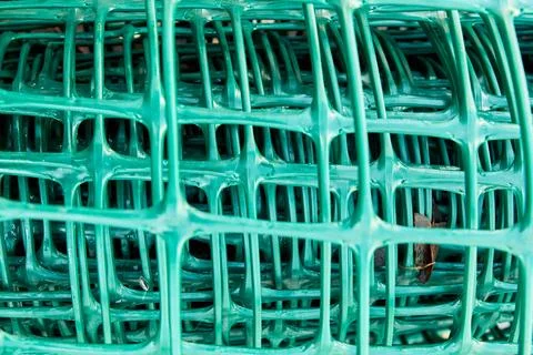 Square pattern green plastic flexible garden fence rolled up Stock-Fotos