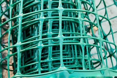 Square pattern green plastic flexible garden fence rolled up Stock-Fotos
