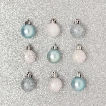 Square pattern made of Christmas balls on a silver textured background. Stock Photos