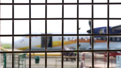 Square pattern of metal grid fence. Airplane on the runway at background. Stock Footage 118588832
