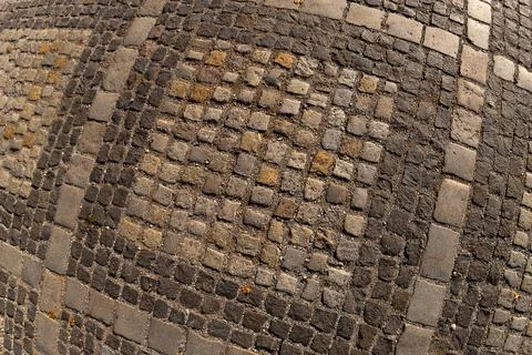 Square pavement paved with gray and brown cobblestones rectangles ornament te Stockfoto's