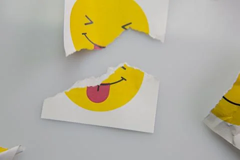 Square piece of paper with the face of a mocking emoji with tongue out. Stock Photos