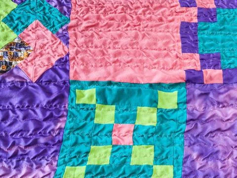 Square pieces of fabrics in stitched patchwork textile background - sewn s... Stock Photos