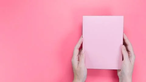 A square pink box with an copy empty space for text and design in hand of y.. Foto stock