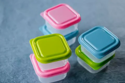 Square plastic containers with bright multi-colored lids. Stockfoto's