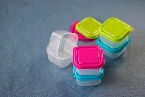 Square plastic containers with bright multi-colored lids. Stock Photos