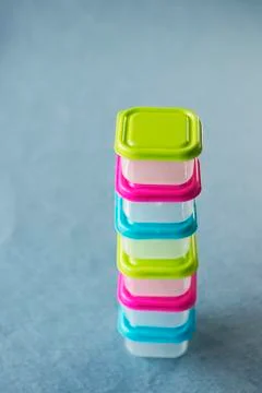 Square plastic containers with bright multi-colored lids. Stock Photos
