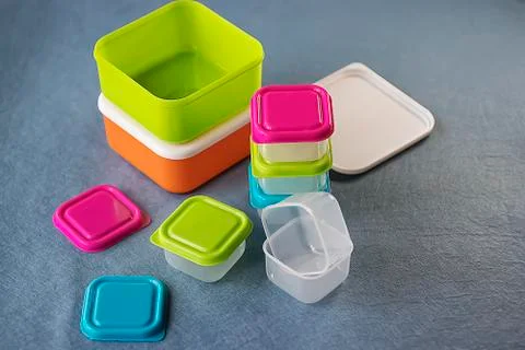 Square plastic containers with bright multi-colored lids. Stock Photos