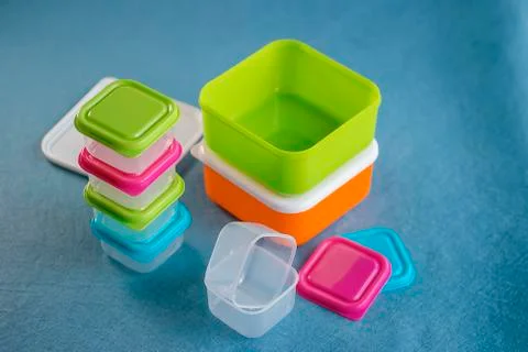 Square plastic containers with bright multi-colored lids. Stock Photos