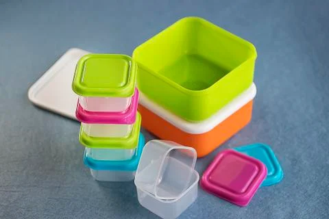 Square plastic containers with bright multi-colored lids. Stock Photos