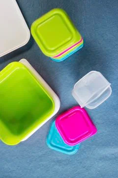 Square plastic containers with bright multi-colored lids. Stock Photos