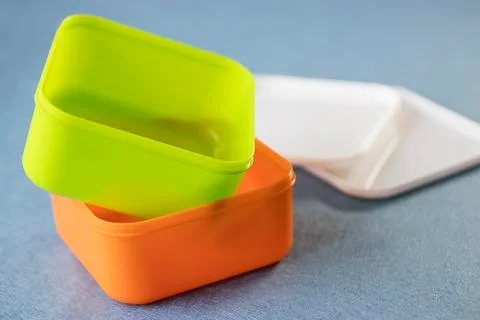 Square plastic containers with bright multi-colored lids. Stock Photos