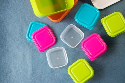 Square plastic containers with bright multi-colored lids. Stock Photos