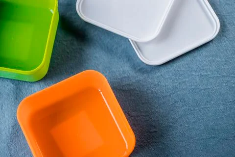 Square plastic containers with bright multi-colored lids. Foto stock