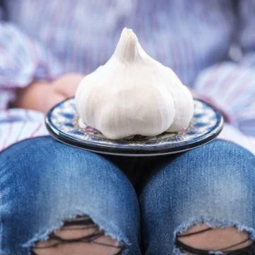 Square pretty image of a child or person holding garlic Stock Photos