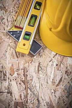 Square ruler Building level Building helmet Wooden metre on chipboard Stock Photos