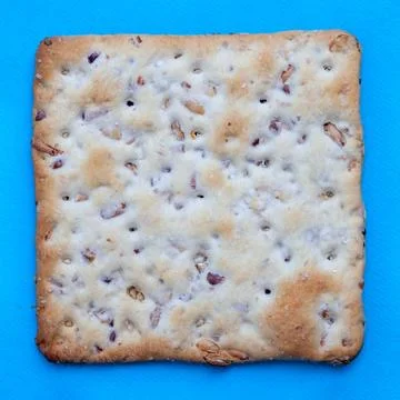 Square salted cracker on blue background - top view closeup Foto stock