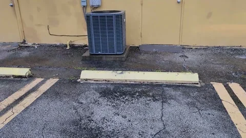 Square shaped AC unit on ground near shopping and office complex Stock Footage 327067282