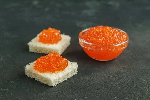 Square shaped wheat bread with red caviar on gray background Foto stock