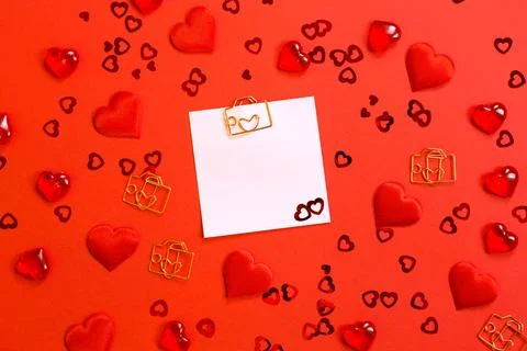 Square sheet for notes with a paper clip in shape of a letter and a heart. .. Stock Photos