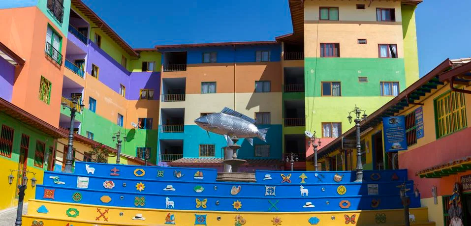 Square with silver fish statue and colorful facades, Guatape Stock Photos