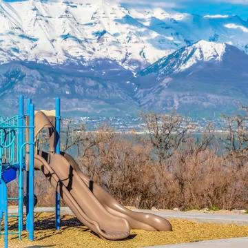 Square Slides on a playground with leafless trees and lake in the background Stock Photos