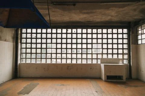 Square small windows and worn ceiling and floor inside a building 写真素材