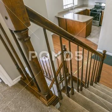 Square Staircase inside a house overlooking the kitchen and an empty room Stock Photos