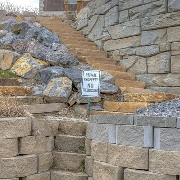 Square Stone retaining wall and steps with No Trespassing sign at a private Stock Photos