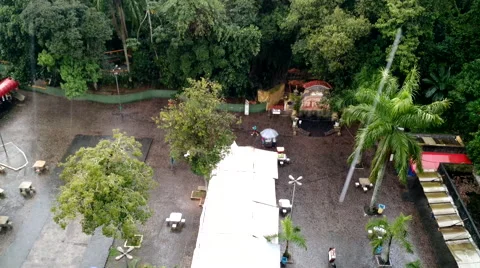Square with strong rain in a cloudy day with few people 4K HD Stock Footage 54366715