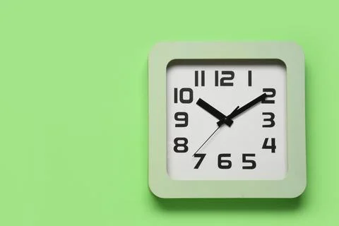 Square wall clock on green background Stock Photos