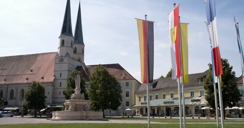 Square with waving flags at beautiful pilgrimage Altötting, Germany 4K Stock Footage 114363601