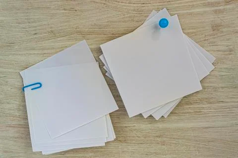 Square white stickers for notes in the office and study on a white wooden bac Stock Photos