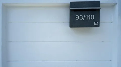 Square white wall background with numbered sign. Stock Photos