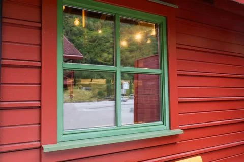 Square window with green frame in red wooden building wall Stock Photos