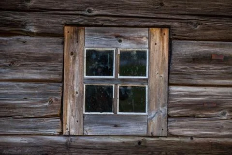 Square window of old one-storey wooden house in the North Stock Photos