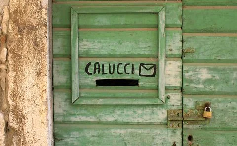 A square wooden frame with a rectangle hole on a green wooden door for leavin Foto stock