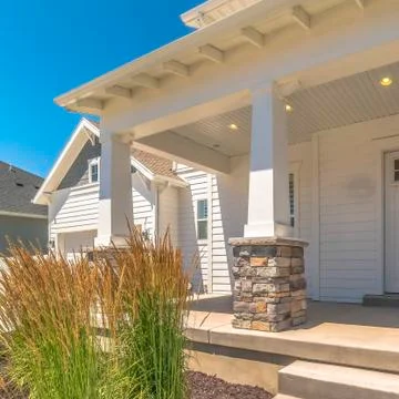 Square Yard pathway and steps that leads to concrete porch and white front door Stock Photos