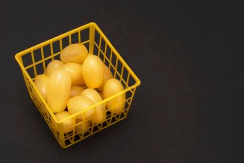 Square yellow grid box with yellow tomatoes on black background Stock Photos